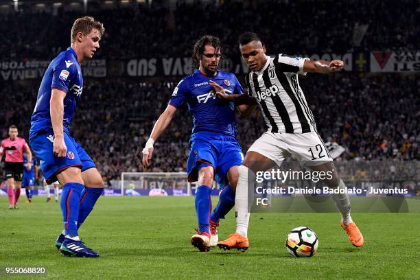 Alex Sandro of Juventus competes for the ball with Andrea Poli of Bologna FC during the serie A match between Juventus and Bologna FC at Allianz...