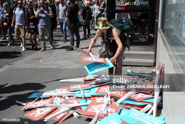Protester prepares placards during a protest dubbed a "Party for Macron" against the policies of the French president on the first anniversary of his...