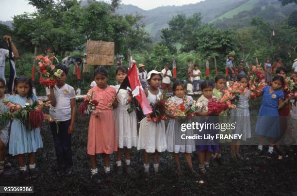 Enfants tenant des bouquets de fleurs lors d'un meeting du ?Front sandiniste de libération nationale? à Managua, en 1985, Nicaragua.