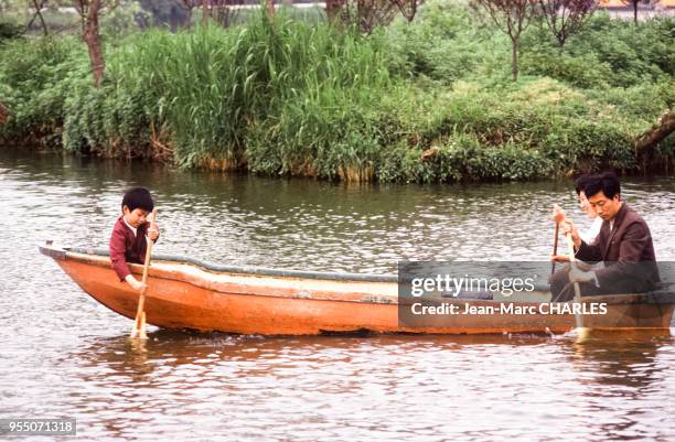 Famille se promenant en barque sur le lac mince de l'ouest à Yangzhou, en mai 1987, Chine.