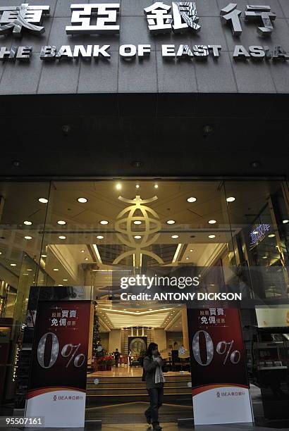 Customers walk out of the Bank of East Asia's headquarters in Hong Kong on December 31, 2009. Spain's La Caixa said on December 30 it had reached an...