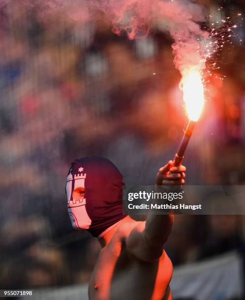 Supporter of Hamburg lights a flare during the Bundesliga match between Eintracht Frankfurt and Hamburger SV at Commerzbank-Arena on May 5, 2018 in...