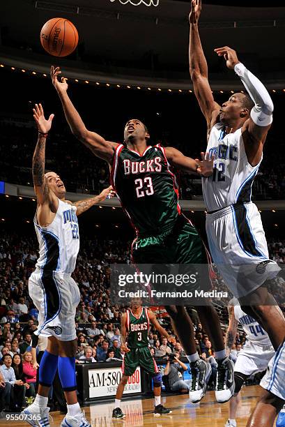 Jodie Meeks of the Milwaukee Bucks shoots against Dwight Howard of the Orlando Magic during the game on December 30, 2009 at Amway Arena in Orlando,...