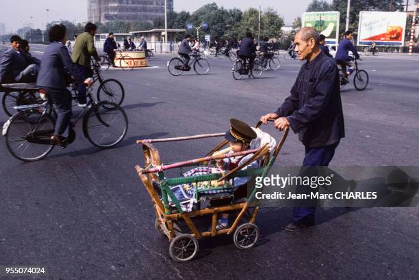 Enfant dans une poussette en bambou à Pékin, en septembre 1986, Chine.