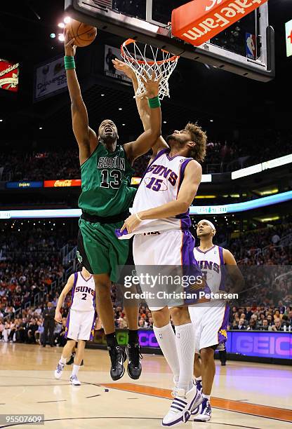 Shelden Williams of the Boston Celtics lays up a shot over Robin Lopez of the Phoenix Suns during the NBA game at US Airways Center on December 30,...