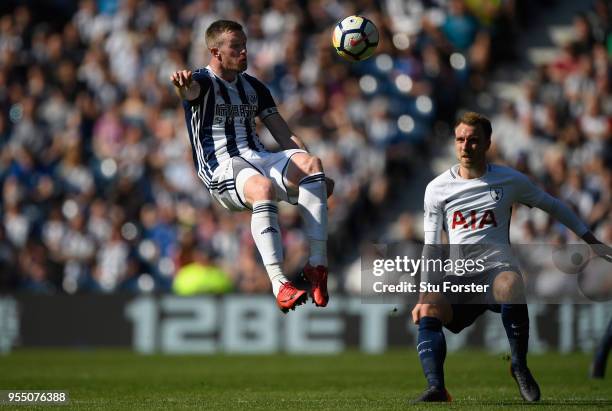 Player Chris Brunt in action watched by Christian Eriksen during the Premier League match between West Bromwich Albion and Tottenham Hotspur at The...