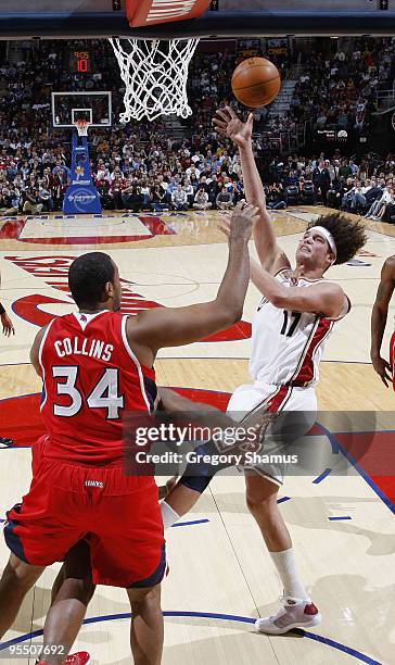 Anderson Varejao of the Cleveland Cavaliers gets a shot off over Jason Collins of the Atlanta Hawks on December 30, 2009 at the Quicken Loans Arena...