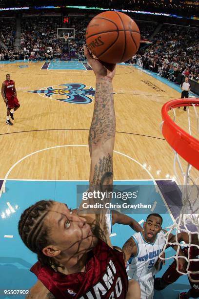 Michael Beasley of the Miami Heat grabs a rebound over Marcus Thornton of the New Orleans Hornets at New Orleans Arena on December 30, 2009 in New...