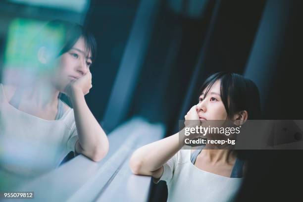 woman thinking deeply by the window - japan woman stock pictures, royalty-free photos & images