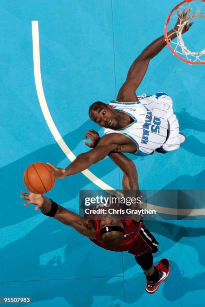 Emeka Okafor of the New Orleans Hornets fights for a rebound with Jermaine O'Neal of the Miami Heat at New Orleans Arena on December 30, 2009 in New...