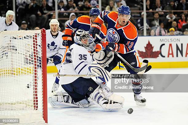 Andrew Cogliano of the Edmonton Oilers looks for the loose puck in front of goalie Vesa Toskala of the Toronto Maple Leafs in the second period...