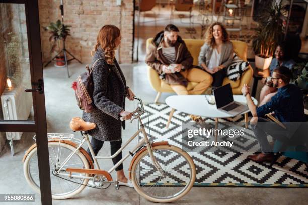 cerca de una mujer entrando en la oficina con bicicleta - hipster persona fotografías e imágenes de stock