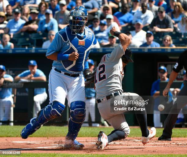 Leonys Martin of the Detroit Tigers scores against Salvador Perez of the Kansas City Royals in the first inning at Kauffman Stadium on May 5, 2018 in...