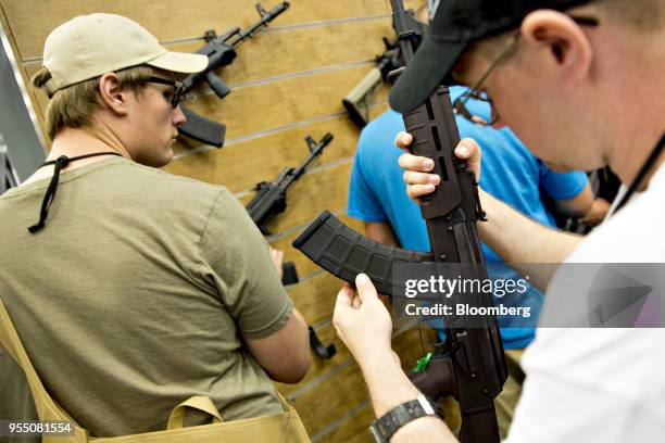 Attendees inspect rifles during the National Rifle Association annual meeting in Dallas, Texas, U.S., on Saturday, May 5, 2018. President Donald...