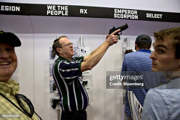 An attendee holds a Sig Sauer Inc. Pistol at the company's booth during the National Rifle Association annual meeting in Dallas, Texas, U.S., on...