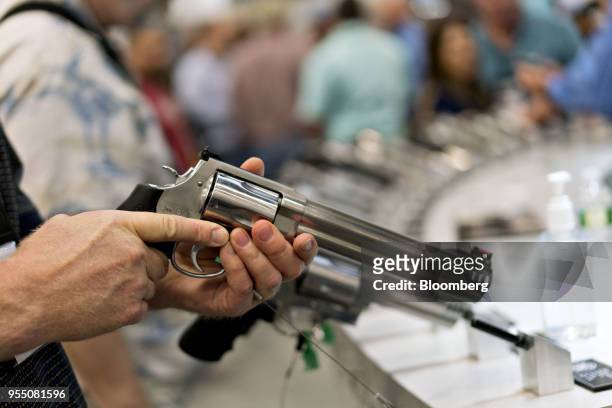 An attendee holds a Smith & Wesson Corp. Revolver at the company's booth during the National Rifle Association annual meeting in Dallas, Texas, U.S.,...