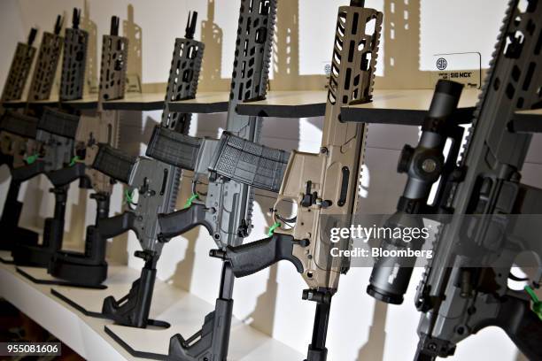 Rack of Sig Sauer Inc. Rifles sit on display at the company's booth during the National Rifle Association annual meeting in Dallas, Texas, U.S., on...