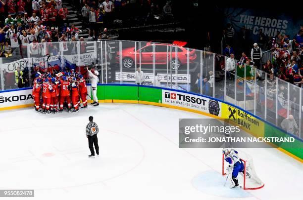 Slovakia's goalie Marek Ciliak takes out the puck from his net as Czech Republic's Dmitrij Jaskin is congratulated by teamates after scoring the...