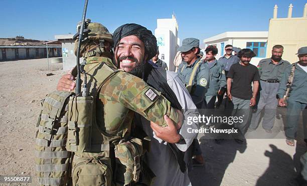 Afghanistan National police district Commander Haji Quari hugs Australia's Lieutenant Matt Cooper from Templestowe in Melbourne, after casting his...