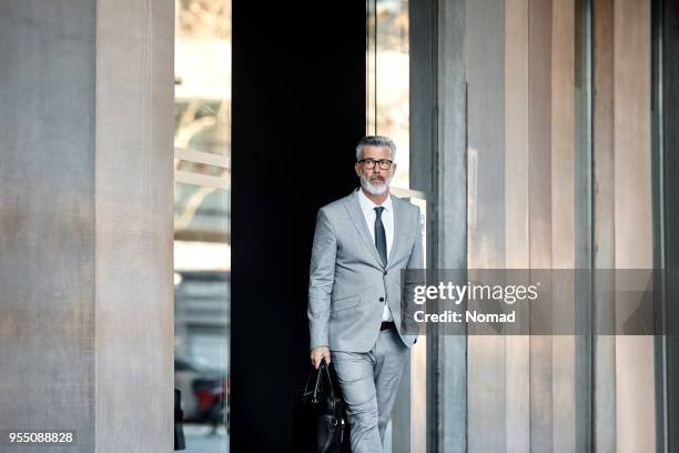 confident businessman leaving from office - well dressed stock pictures, royalty-free photos & images