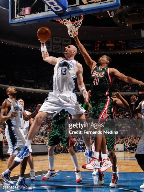 Marcin Gortat of the Orlando Magic pulls down a rebound against Kurt Thomas of the Milwaukee Bucks during the game on December 30, 2009 at Amway...