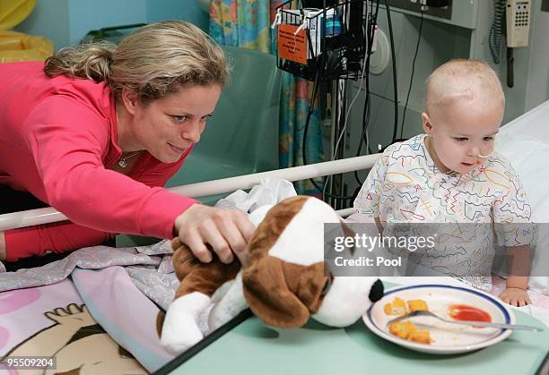 Kim Clijsters of Belgium gestures to a young patient while on a visit to the Royal Brisbane Childrens Hospital on December 31, 2009 in Brisbane,...