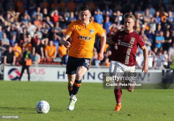 George Edmundson of Oldham Athletic looks to the ball as he is pursued by Sam Hoskins of Northampton Town during the Sky Bet League One match between...