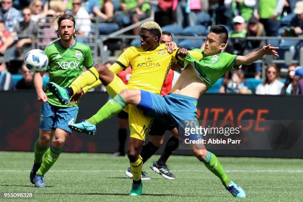 Gyasi Zerdes of Columbus Crew fights for the ball against Kim Kee-hee of the Seattle Sounders during their game at CenturyLink Field on May 5, 2018...
