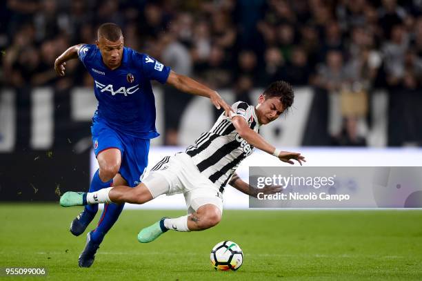 Sebastien De Maio of Bologna FC competes for the ball with Paulo Dybala of Juventus FC during the Serie A football match between Juventus FC and...