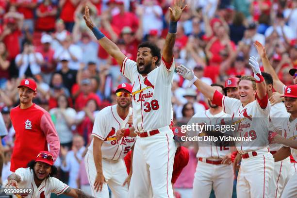 Jose Martinez and Harrison Bader of the St. Louis Cardinals celebrate with teammates after beating the Chicago Cubs in the tenth inning at Busch...