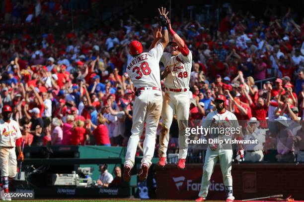 Jose Martinez and Harrison Bader of the St. Louis Cardinals celebrate after tying the game against the Chicago Cubs in the ninth inning at Busch...
