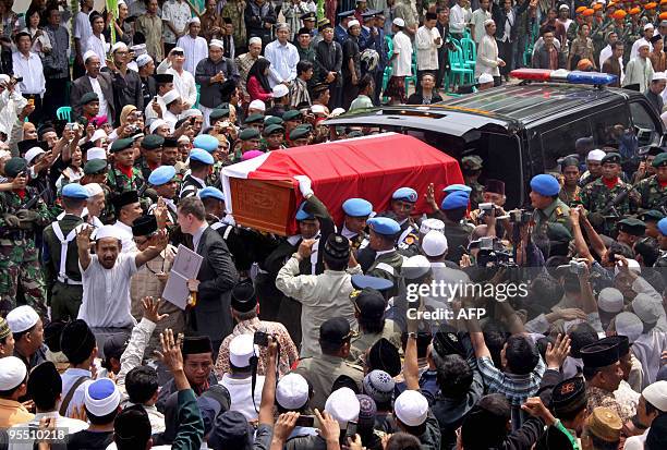 Indonesian soldiers carry a coffin of the late former Indonesian president Abdurrahman Wahid, also known as Gus Dur, as supporters look on during his...