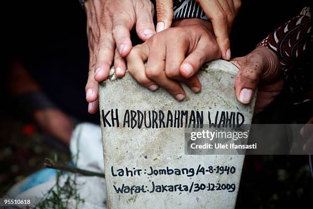 Supporters touch the gravestone of former Indonesia president Abdurrahman Wahid during his burial in his East Java hometown on December 31, 2009 in...