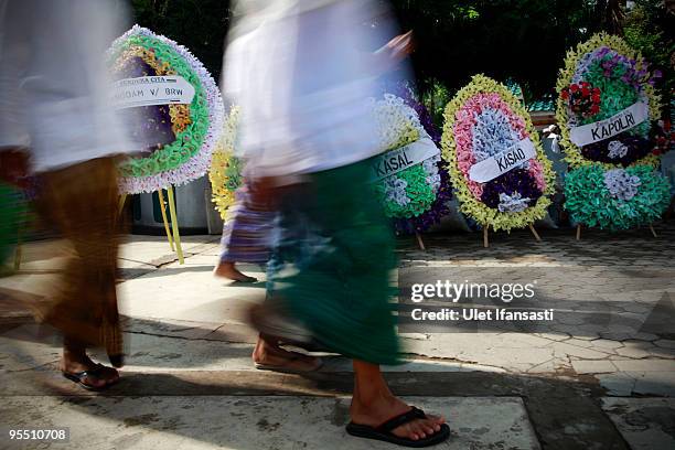 Supporters walking through flower bouquets at the State funeral for former Indonesia president Abdurrahman Wahid in his East Java hometown on...