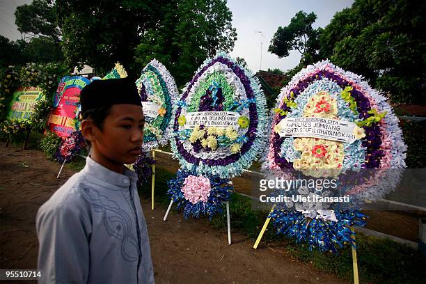 Supporter walks through flower bouquets at the State funeral of former Indonesia president Abdurrahman Wahid in his East Java hometown on December...