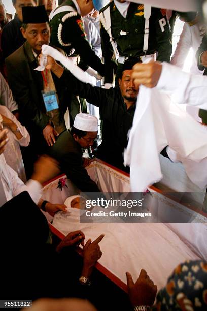 Indonesian Muslim clerics prepare the body of former Indonesian President Abdurrahman Wahid before his funeral on December 31, 2009 in Jombang,...