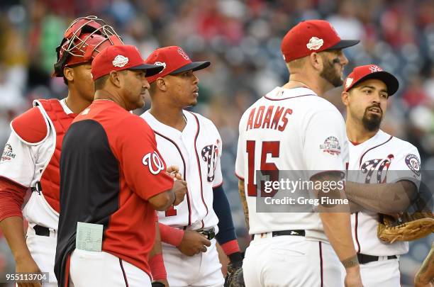 Manager Dave Martinez of the Washington Nationals talks to his players during a pitching change in the seventh inning against the Philadelphia...