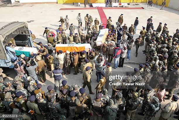 Indian police officers of Central Reserve Police Force carry the coffins of their dead colleagues during a wreath laying ceremony on December 31,...