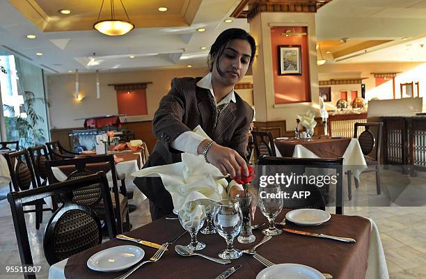 An employee decorates a table at the Pearl Continental Hotel on its reopening in Peshawar on December 31 following a deadly bombing this year. The...