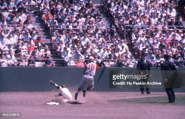 Don Blasingame of the Cincinnati Reds throws the ball to first as Harvey Kuenn of the San Francisco Giants slides into the bag during an MLB game on...