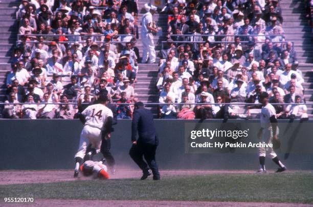 Joey Amalfitano of the San Francisco Giants runs to tag out Vada Pinson of the Cincinnati Reds as Orlando Cepeda of the Giants looks on during an MLB...