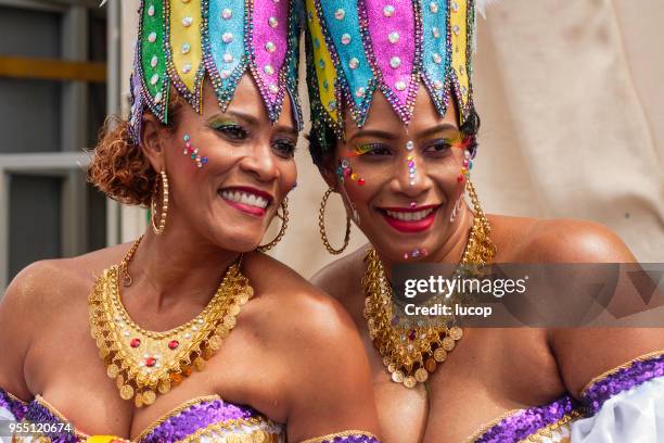 carnival celebration event at curacao, colourful dressed woman smiling during parade - curacao stock pictures, royalty-free photos & images