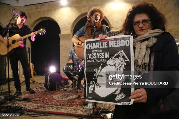 Femme montrant la couverture du numéro anniversaire de Charlie Hebdo lors de l?hommage aux victimes des attentats terroristes des 6 et 7 janvier...