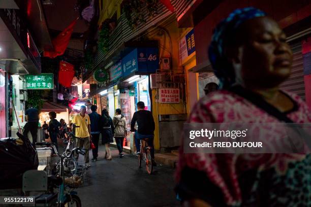 In this photo taken on March 1 people walk in the "Little Africa" district in Guangzhou, the capital of southern China's Guangdong province. - The...
