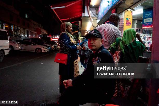 In this photo taken on March 1 a Chinese security man looks on at the entrance to the "Little Africa" district in Guangzhou, the capital of southern...