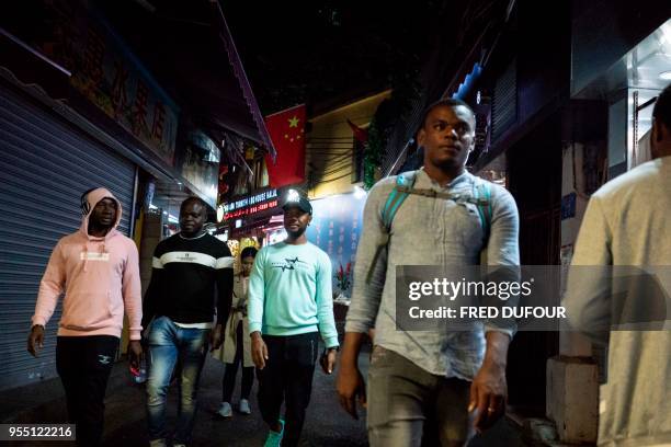 In this photo taken on March 1 people walk in the "Little Africa" district in Guangzhou, the capital of southern China's Guangdong province. - The...