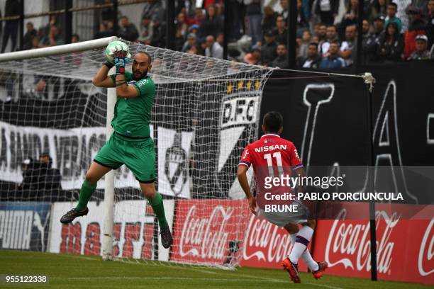 Danubio's goalkeeper Federico Cristoforo grabs the ball kicked by Nacional's footballer Leonardo Barcia during their Uruguayan Apertura tournament...