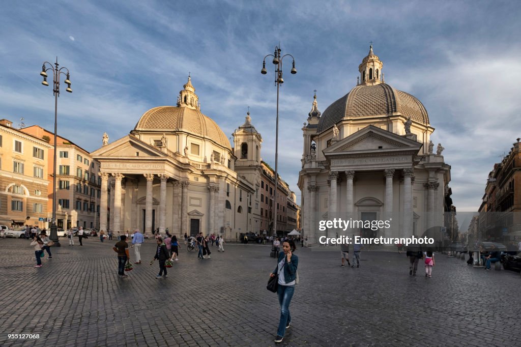 The twin churches with people walking in the foreground at Piazza del Popolo,Rome.