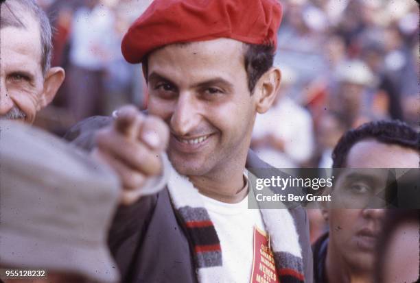 Close-up of an unidentified man in a red beret smiles as he points at the camera from the audience in la Plaza de la Revolucion during the 10th...