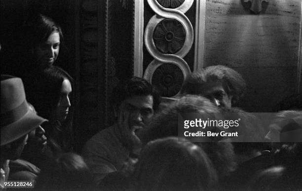 View of German-born American concert promotor Bill Graham surrounded by unidentified others in the lobby of the Filmore East during the venue's...